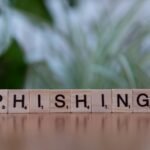 Wooden tiles spelling 'phishing' highlight cybersecurity themes.