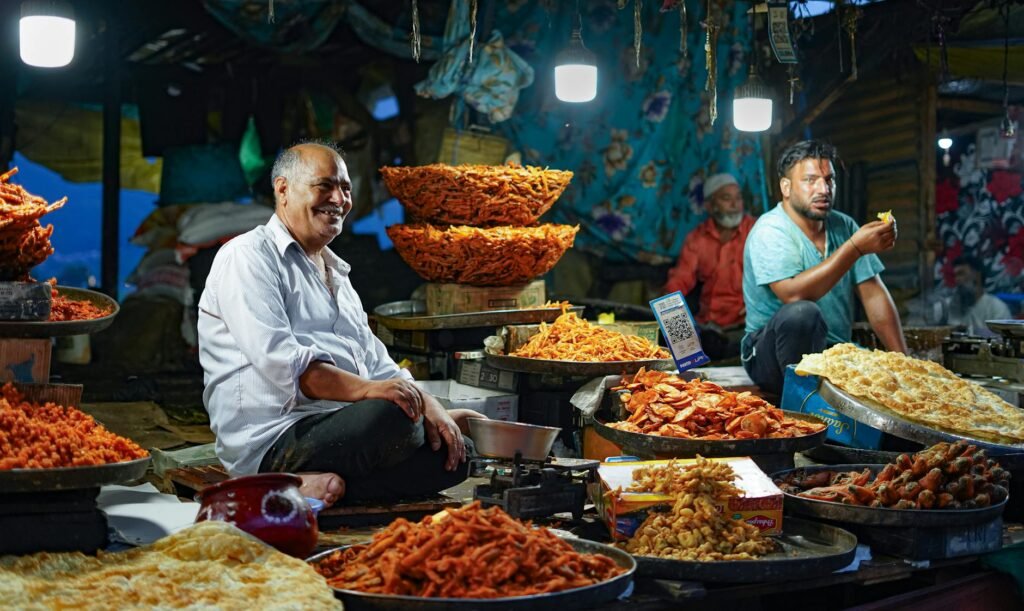 Lively street market in Srinagar, India showcasing local vendors selling traditional snacks under bright lights.